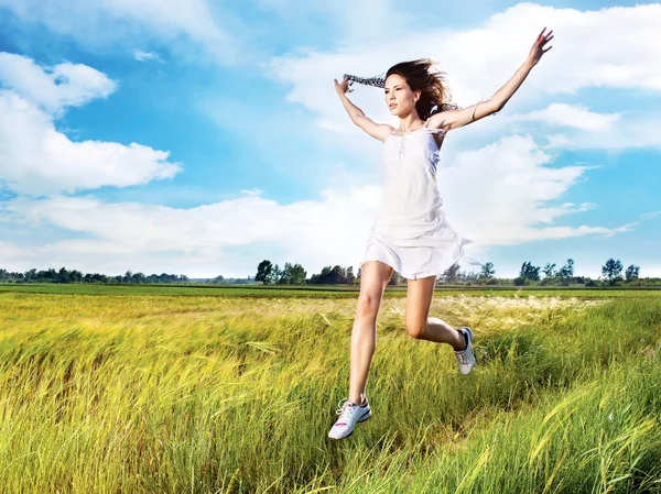 Woman running across field — Stock Photo, Image