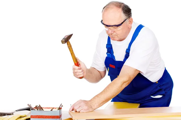 Worker knocking the nail in board — Stock Photo, Image
