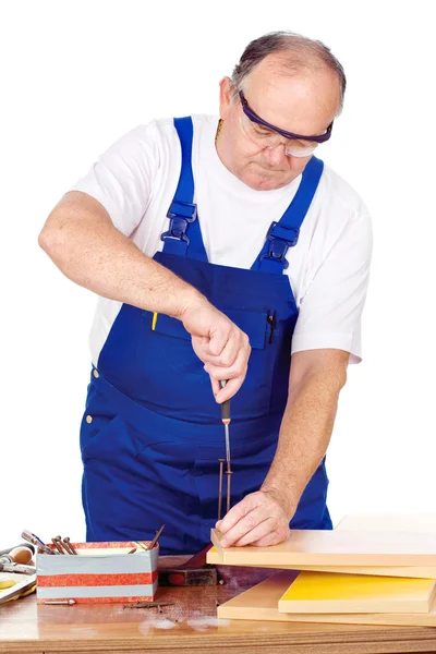 Middle age worker screwing nail in panel board — Stock Photo, Image