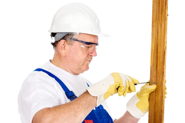 Middle age worker screwing nail in board — Stock Photo, Image