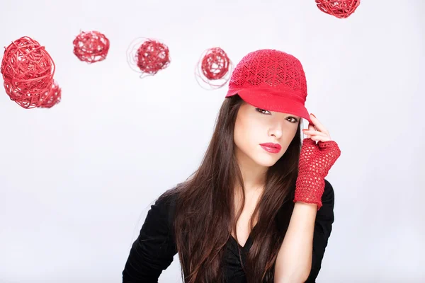 Kvinna med röd hatt mellan röda bollar — Stock fotografie
