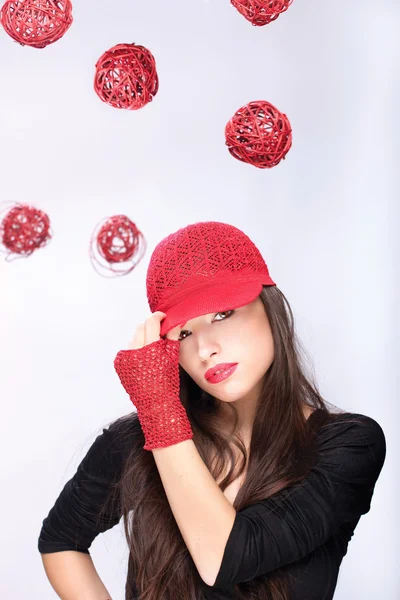 Γυναίκα με κόκκινο καπέλο μεταξύ κόκκινες μπάλες — Φωτογραφία Αρχείου