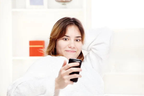 Tiener meisje verrast kijken naar mobiele telefoon — Stockfoto