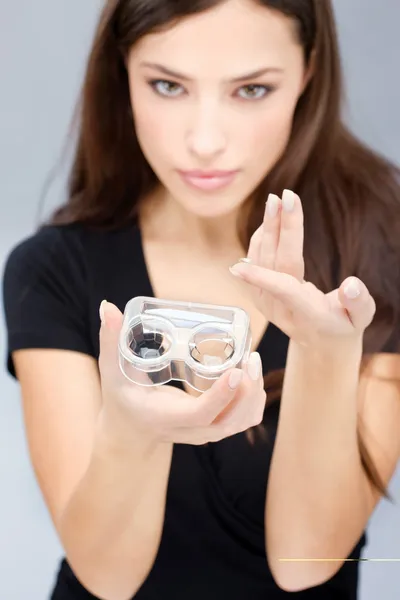 Женщина держит футляры и линзы для контактных линз — стоковое фото