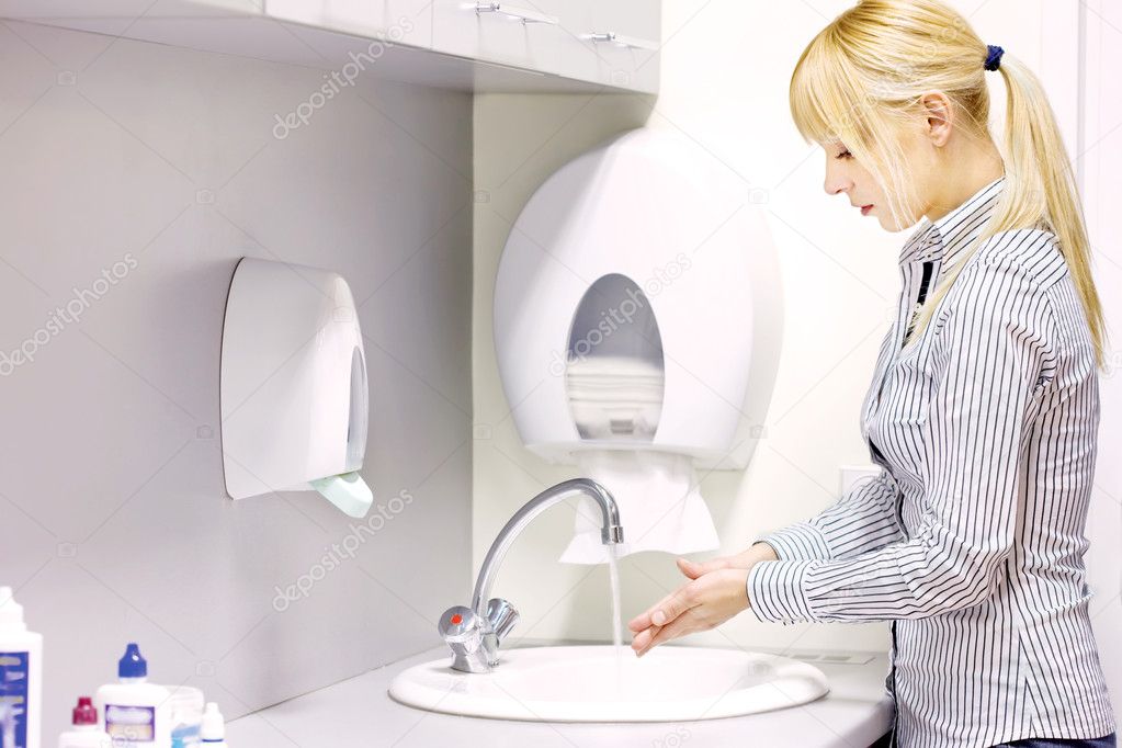 Woman washing hands in restroom