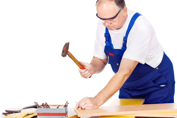 Middle age worker knocking the nail in board — Stock Photo, Image