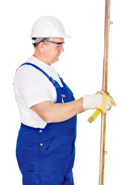 Middle age worker measuring the board — Stock Photo, Image