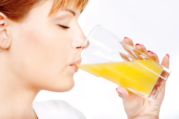 Красивая женщина пьет апельсиновый сок — стоковое фото