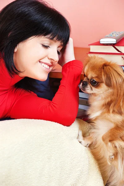 Sorriu menina em casa com seu cão Pekingese — Fotografia de Stock