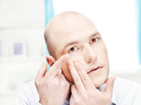 Homem colocando lente de contato em seu olho — Fotografia de Stock