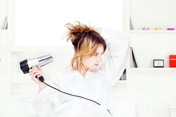 Chica secándose el pelo en casa — Foto de Stock