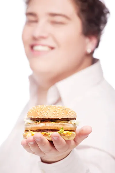 Hamburger in hand of a young chubby man — Stock Photo, Image
