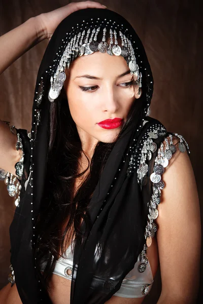 Mulher coberta com cachecol preto segurando a mão em sua cabeça — Fotografia de Stock