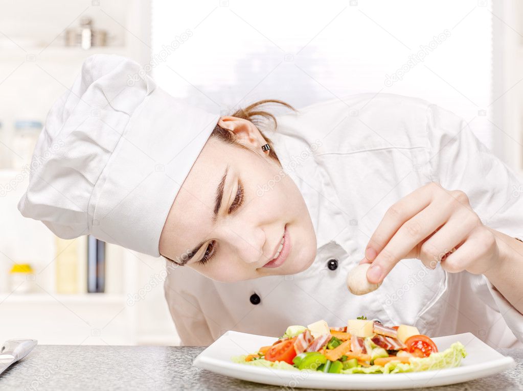 Young chef decorating delicious salad