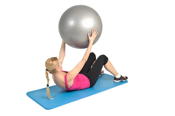 Vrouwelijke liggen abs kraken oefening met fitness bal — Stockfoto