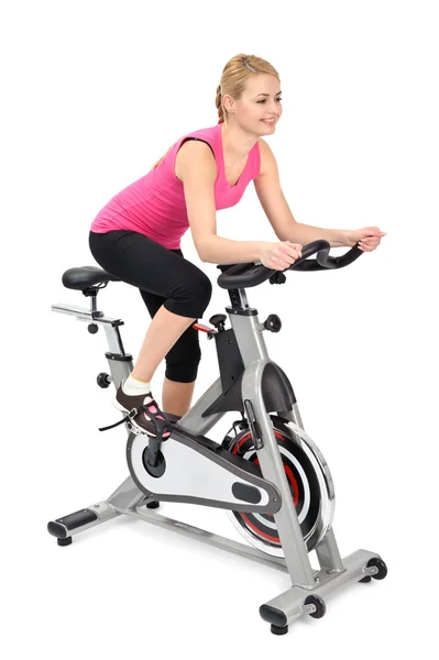 年轻女子室内骑自行车锻炼 — 图库照片