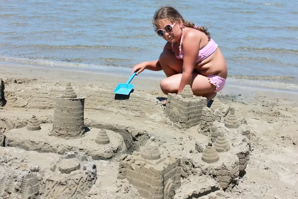 Menina fazendo castelo de areia — Fotografia de Stock