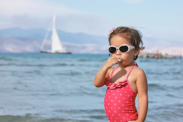 Girl with lollipop on the sea — Stock Photo, Image