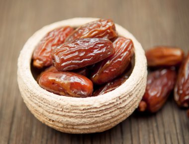 Delicious dates in small bowl clipart