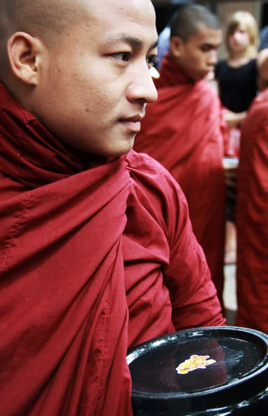 Мьянма монах несет миску, ожидая в очереди на ежедневный обед — стоковое фото