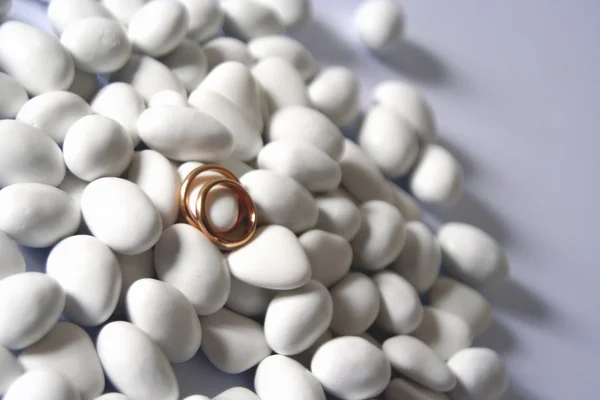 Wedding rings and white comfits — Stock Photo, Image
