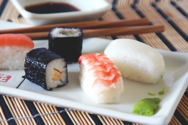 Sushi-Teller auf Bambus-Tischdecke — Stockfoto
