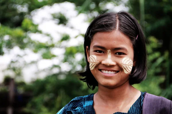 Myanmar meisje met tanaka crème op haar wangen glimlachen — Stockfoto