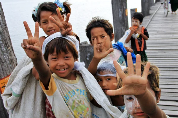 Glückliche kinder auf der u-bein brücke in amarapura, mandalay, myanmar — Stockfoto