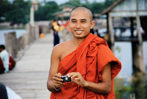 Myanmar keşiş Man u-bein köprüde bir turist için fotoğraf çekme — Stok fotoğraf