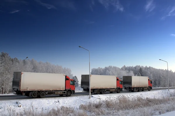 Három kamion, téli úton Stock Fotó