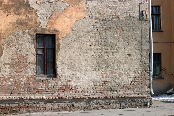 Muur van de oude bakstenen huis met een smal venster Rechtenvrije Stockafbeeldingen