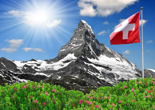 Красивая гора Маттерхорн со швейцарским флагом — стоковое фото