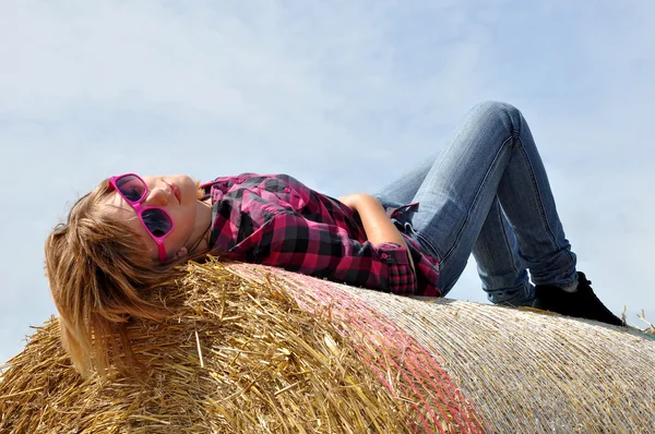 Dívka ležela na balíků slámy — Stock fotografie
