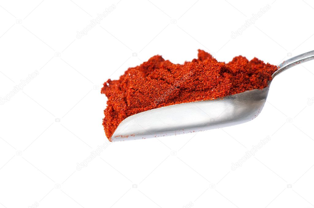 Silver spoon with red paprika powder on white background