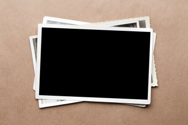 Stack of old photos on gray cardboard background clipart