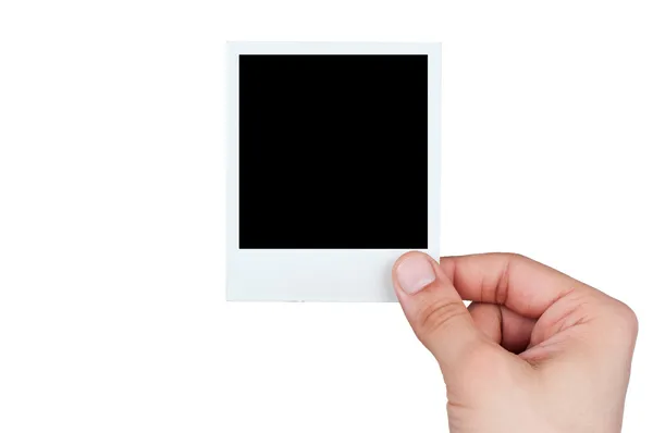 Junge männliche Hand hält Instant-Foto vor weißem Hintergrund lizenzfreie Stockbilder