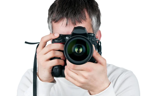 Ung man med kamera, isolerad på vit bakgrund, ligger fokus på objektivet — Stockfoto