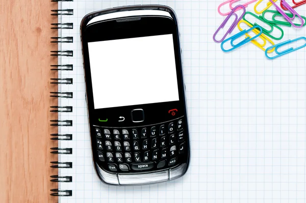 Arbetsplatsen med mobiltelefon, papper, penna och klipp på tabellen arbete. mobiltelefon på ett skrivbord med urklippsbana — Stockfoto