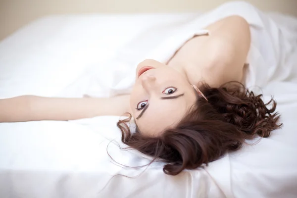 Красивая женщина лежит на кровати — стоковое фото
