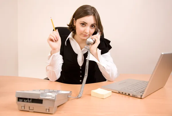 Young secretary with telephone and pencil — Stock Photo, Image