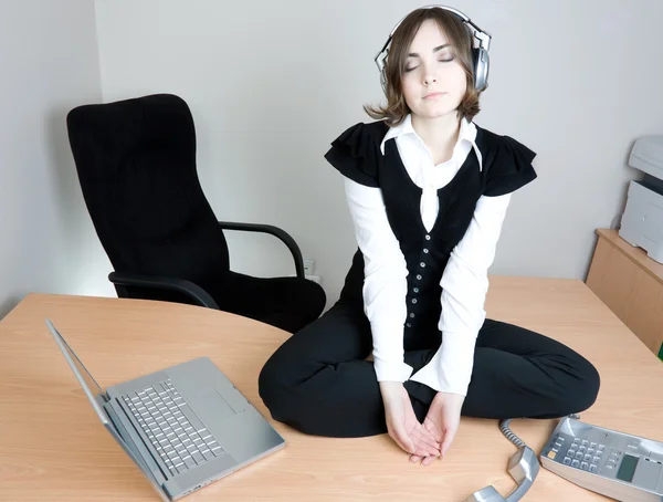 Młoda kobieta siedzi na biurku — Zdjęcie stockowe