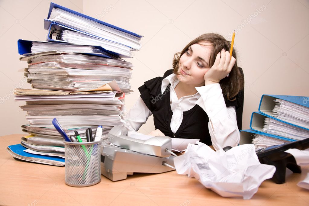 Young businesswoman with tons of documents