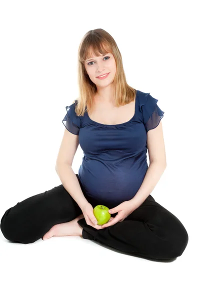 Beautiful pregnant woman holding green apple looking to the came — Stock Photo, Image