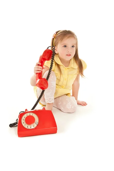 与旧的红色电话的小女孩 — 图库照片