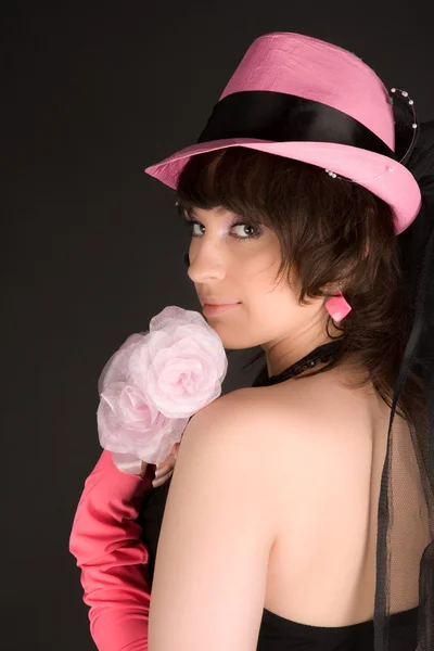Dziewczyna w czarnej sukni ze stawianiem kapelusz — Zdjęcie stockowe