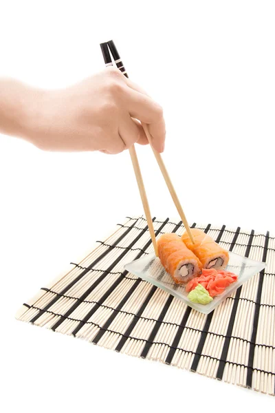 Woman's hand with chopsticks and maki sushi — Stock Photo, Image