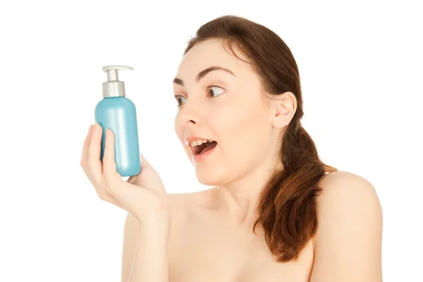 Bild av en vacker förvånad kvinna med en flaska av en kräm — Stockfoto
