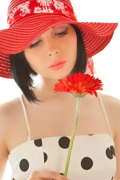 Женщина смотрит на красную герберу — стоковое фото
