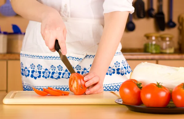 Kvinnans händer skära tomat — Stockfoto