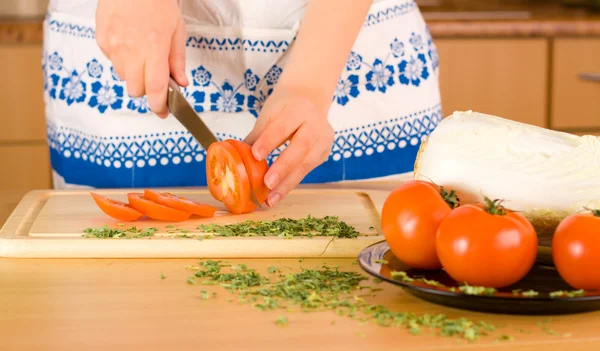 Ženské ruce řezání rajče — Stock fotografie
